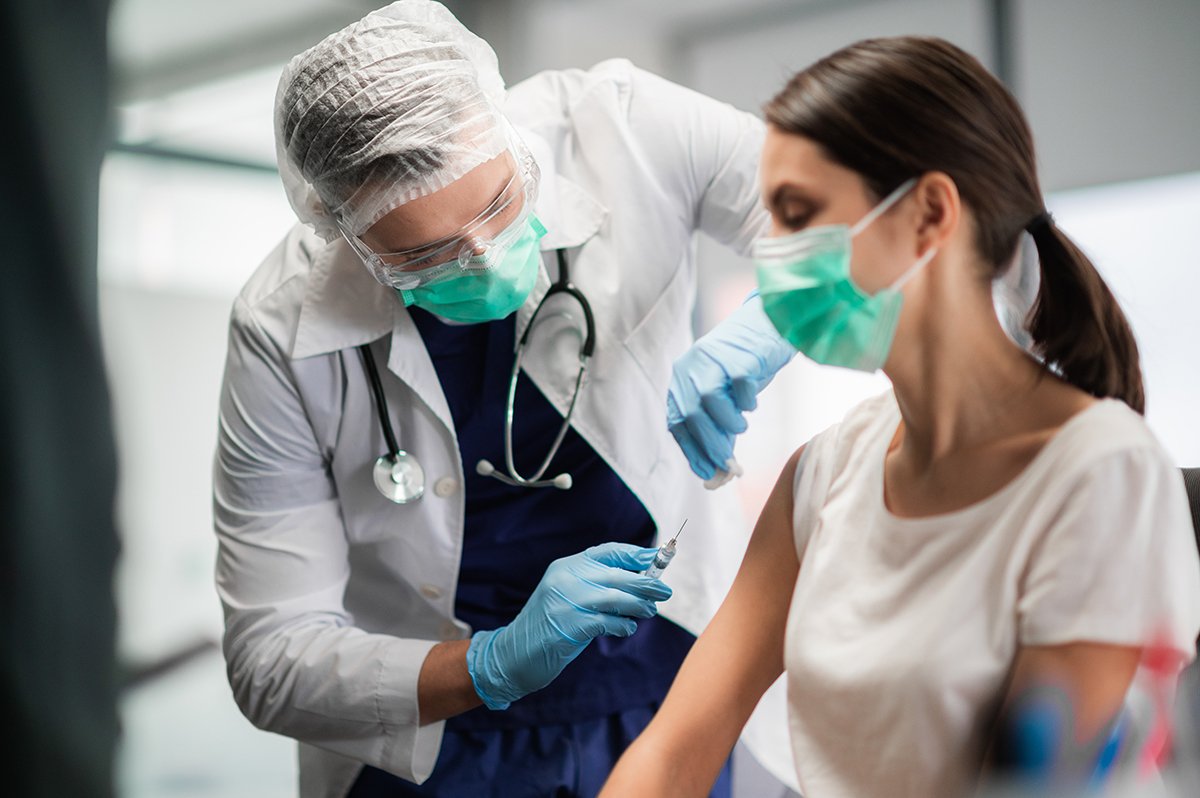 A medical worker administering a COVID vaccine. Accurate epidemiological models are vital for decisions like medical resource allocation and vaccination coverage to effectively manage epidemics.