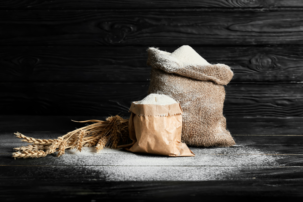 Wheat flour in front of a dark wooden background